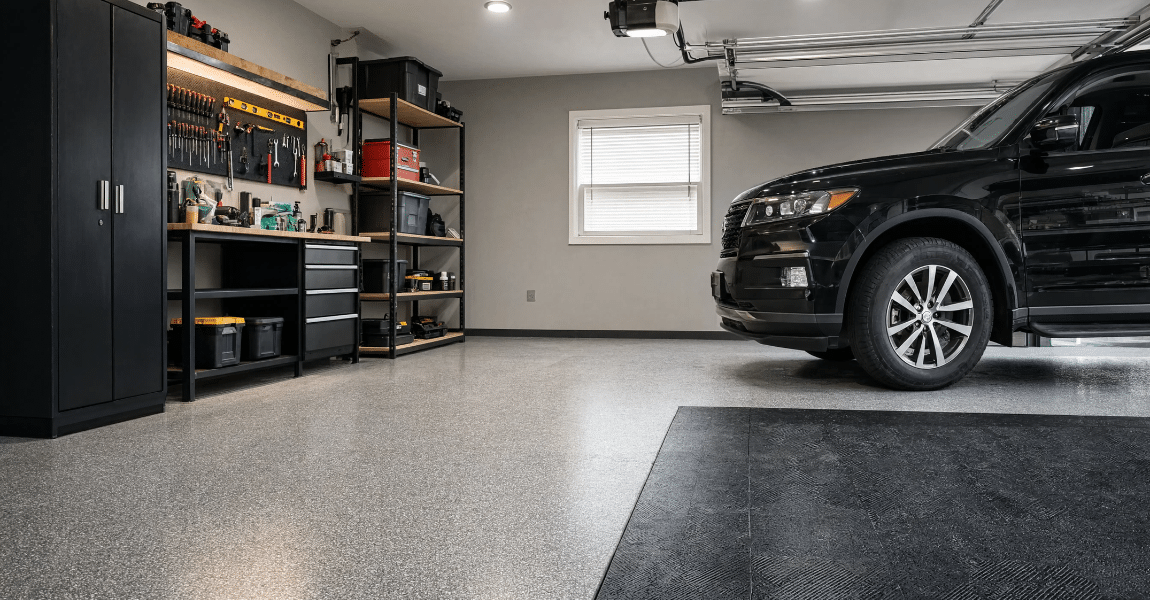 Modern home garage with an epoxy-coated floor and garage tiles, showing durable flooring options that can withstand parked vehicles
